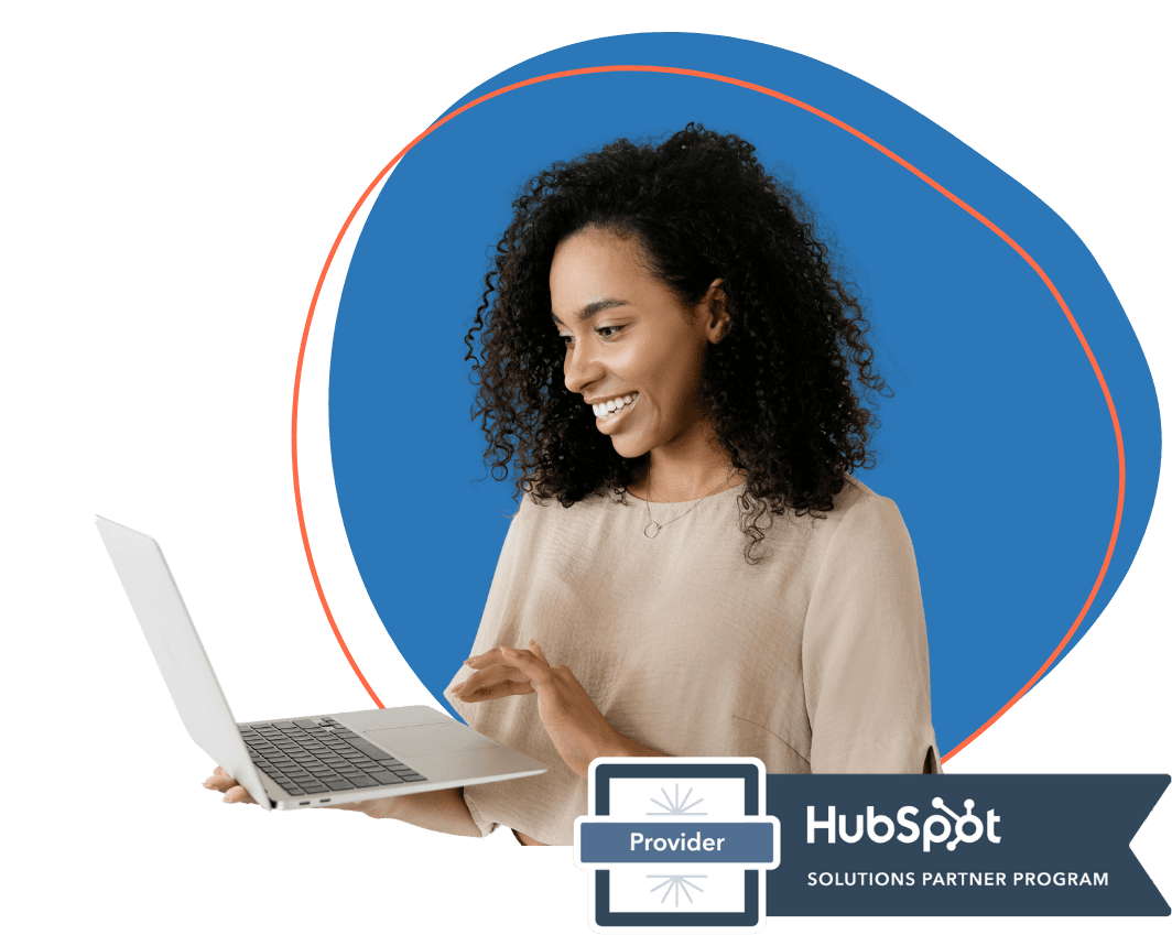 Professional woman working on laptop with HubSpot Solutions Partner Program badge